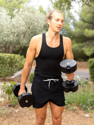 Sportif réalisant un entraînement structuré avec haltères réglables FitnesStorm, illustrant la méthode 3-2-1 pour atteindre ses objectifs.