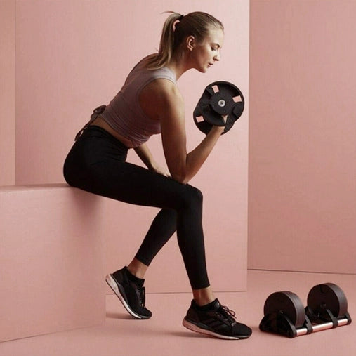 Femme en séance de musculation avec haltères dans un décor épuré, illustrant l’entraînement à domicile avec matériel compact.